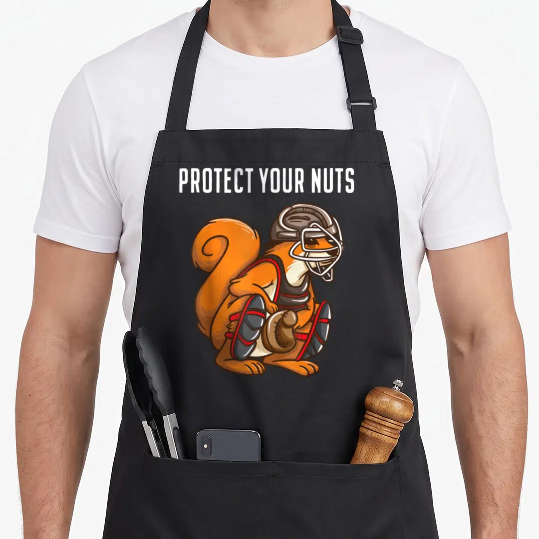 Baseball squirrel aprons - Cartoon squirrel wearing grey football helmet and red pads holding a brown ball under white — shown on a black cotton canvas apron against a white background