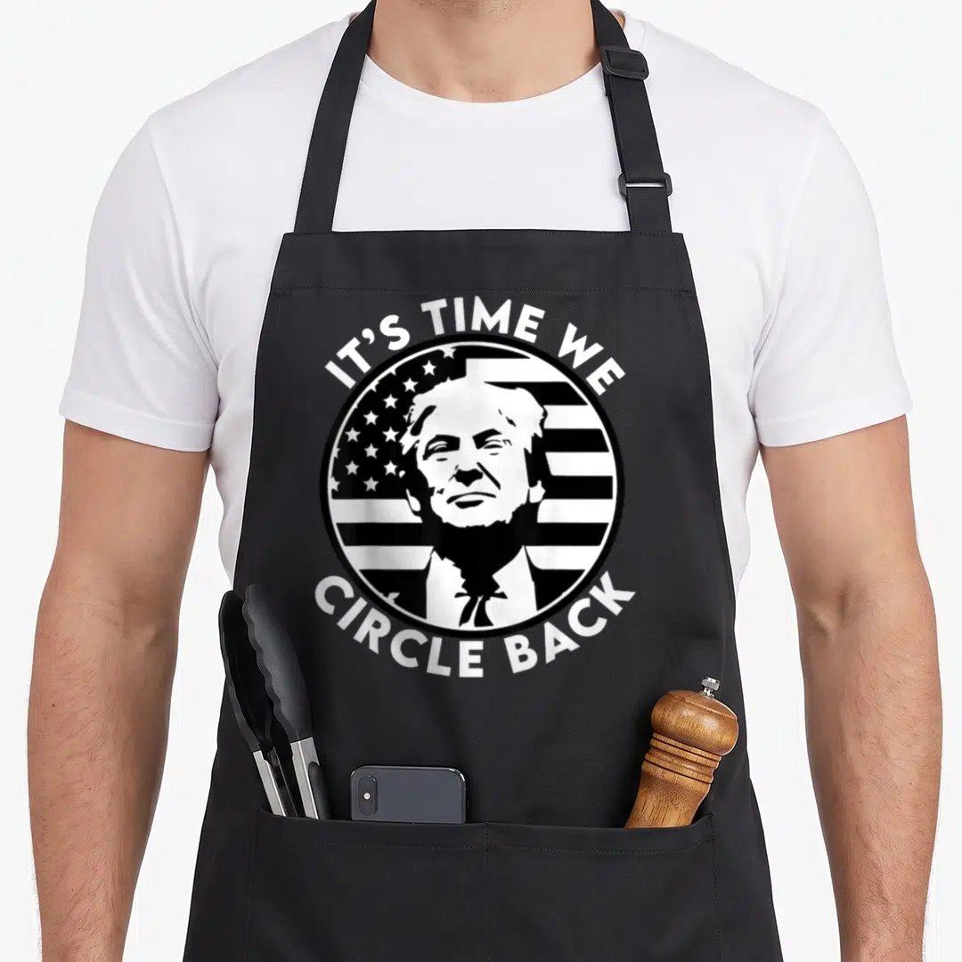 Circle presidents apron - White circular emblem with Trump portrait and flag stripes reading IT'S TIME WE CIRCLE BACK — shown on a black cotton canvas apron against a white background
