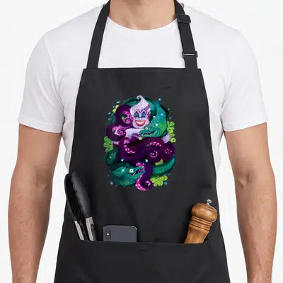 Sea witch apron - Fantasy creature surrounded by purple and green swirling tentacles and serpents in digital art — shown on a black cotton canvas apron against a white background