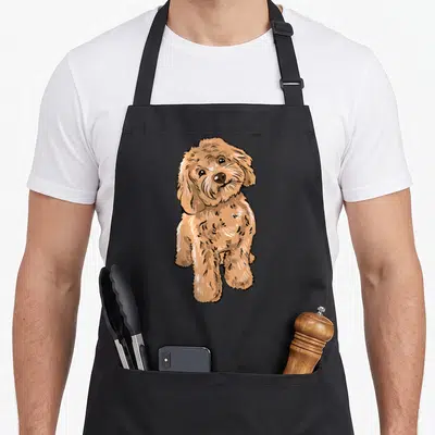 Illustration cockapoo apron - Cartoon cockapoo dog in tan and brown sitting pose — shown on a black cotton canvas apron against a white background