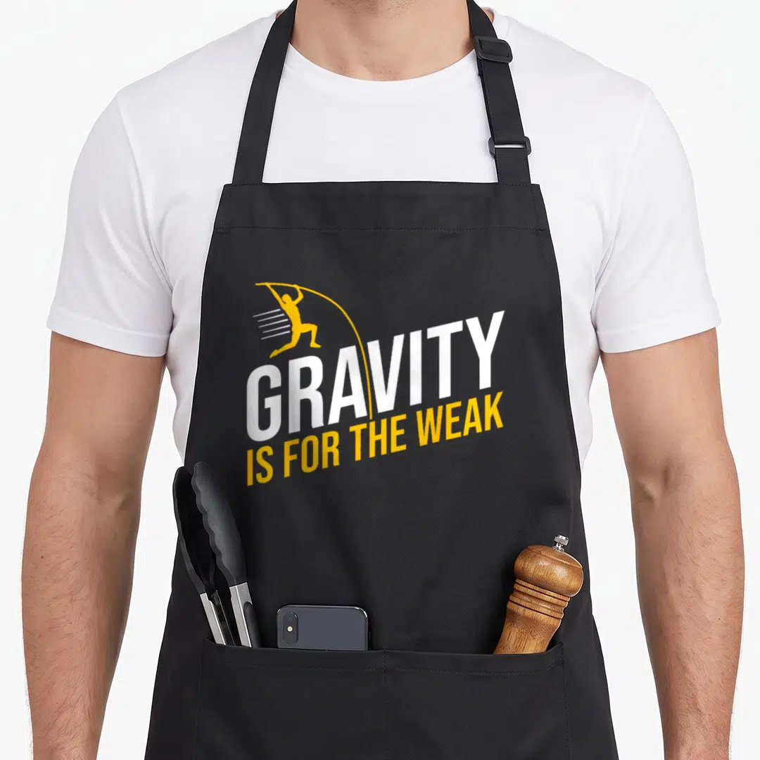Pole basin utpb apron - Gravity Is For The Weak text with yellow vaulting silhouette and white lettering — shown on a black cotton canvas apron against a white background