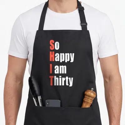 Thirty 30th birthday apron - Stacked text So Happy I am Thirty with red vertical initials forming an acronym in bold — shown on a black cotton canvas apron against a white background