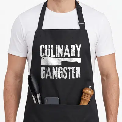 Koch gangster culinary aprons - White distressed cleaver graphic between CULINARY and GANGSTER text — shown on a black cotton canvas apron against a white background