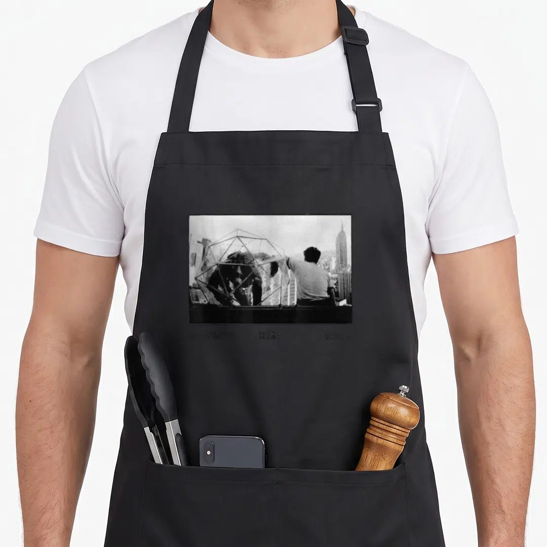 Someone mary apron - Black and white photo of a man near a wireframe structure with three columns of text below — shown on a black cotton canvas apron against a white background