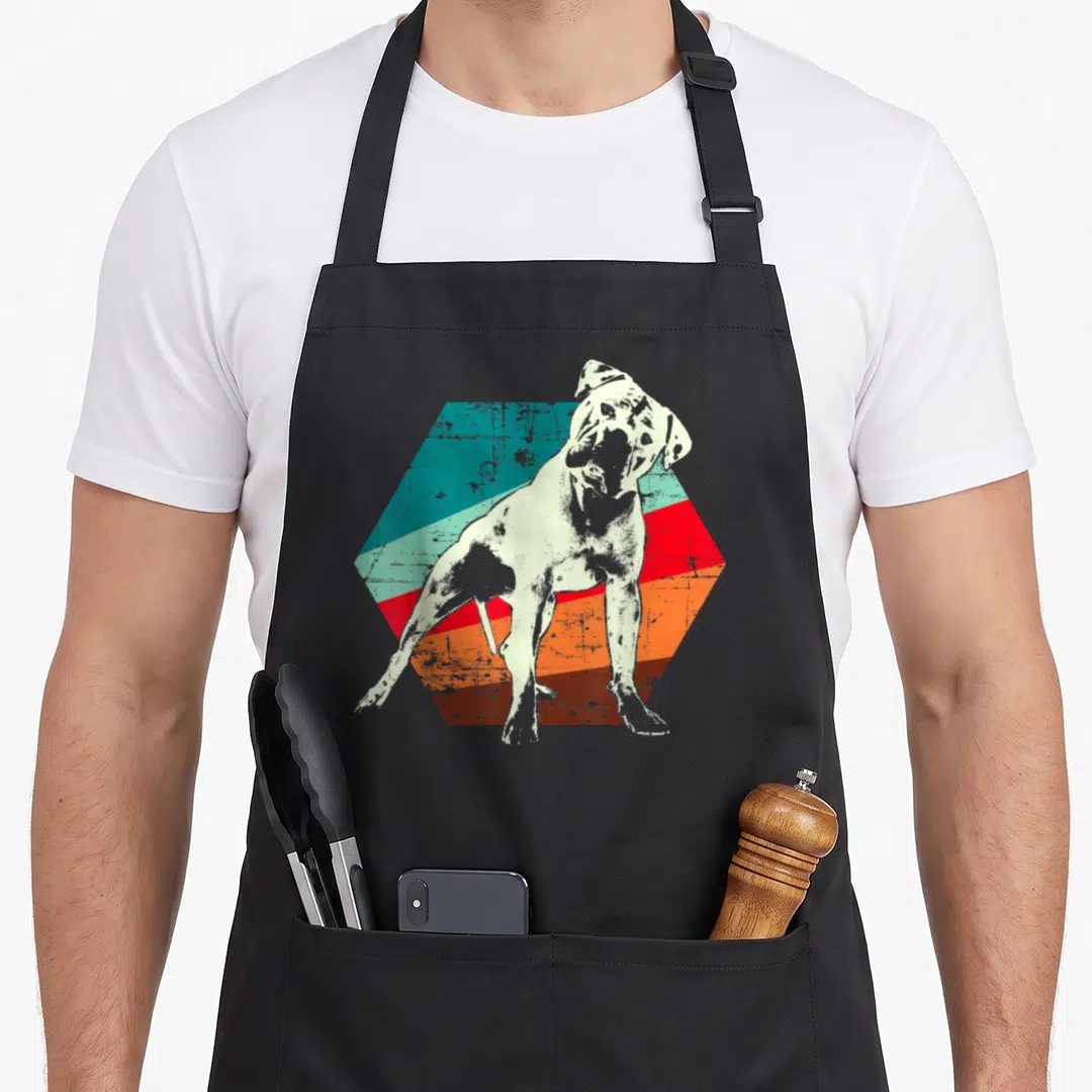 Funny bulldog southern aprons - Distressed white bulldog standing on a striped teal red orange brown hexagon — shown on a black cotton canvas apron against a white background