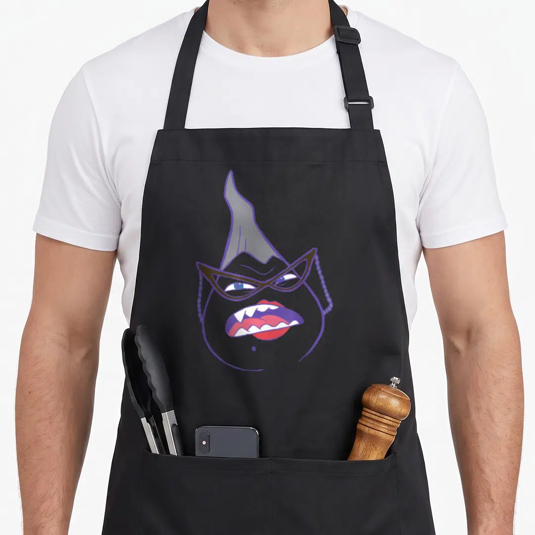 Roz boy monster apron - Cartoon grey monster head with purple glasses outline and red lips showing white teeth — shown on a black cotton canvas apron against a white background
