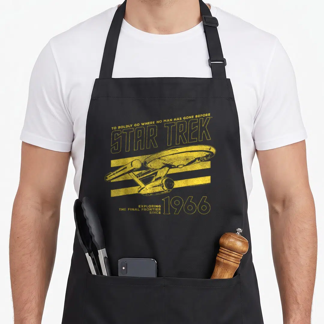 Original collegiate aprons - Yellow Star Trek Enterprise ship over three lines with 1966 text — shown on a black cotton canvas apron against a white background