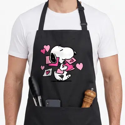 Letter valentine apron - White cartoon dog holding pink envelopes surrounded by pink hearts — shown on a black cotton canvas apron against a white background