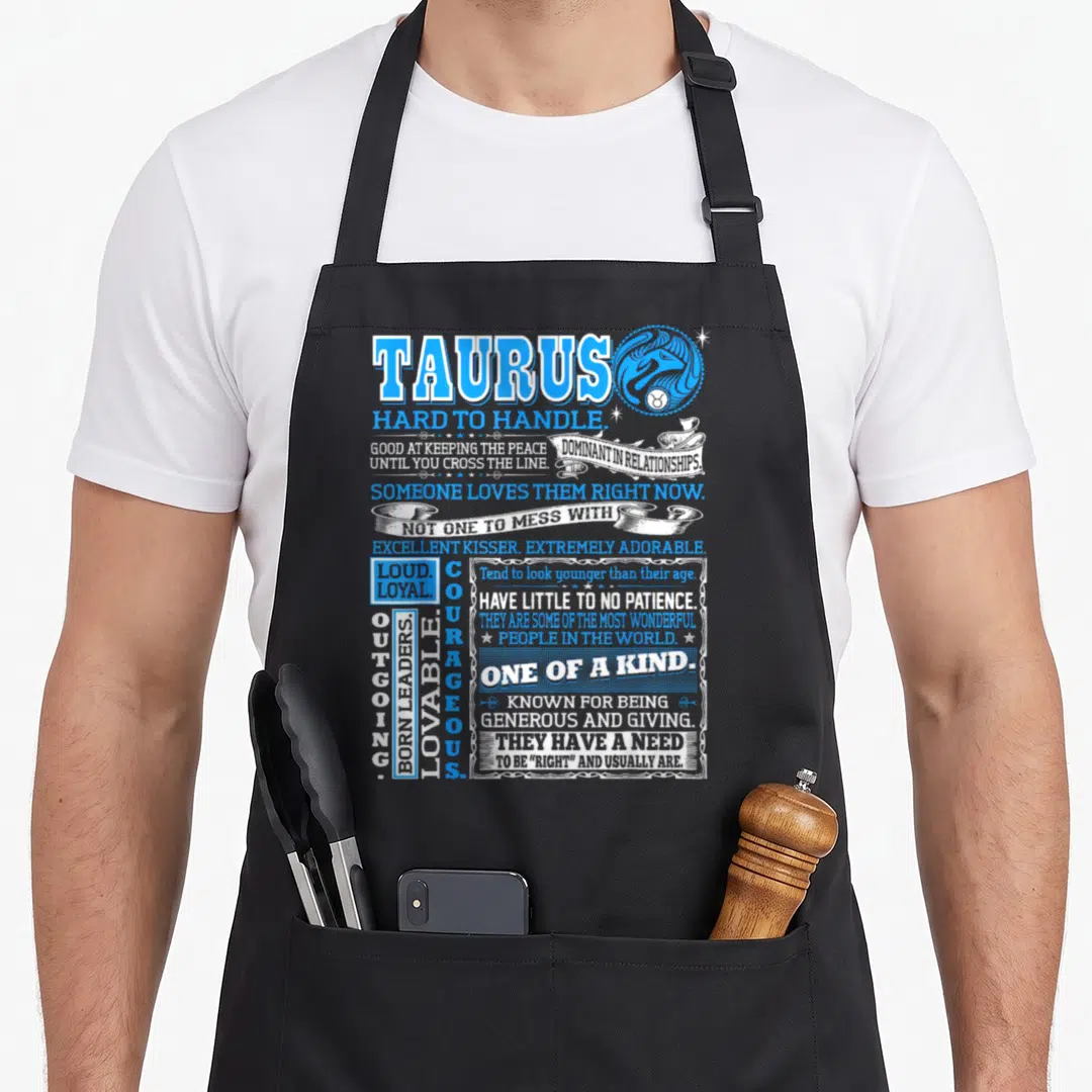 Hard taurus aprons - Taurus Hard To Handle typography design with bull symbol and overlapping banners in blue and white — shown on a black cotton canvas apron against a white background