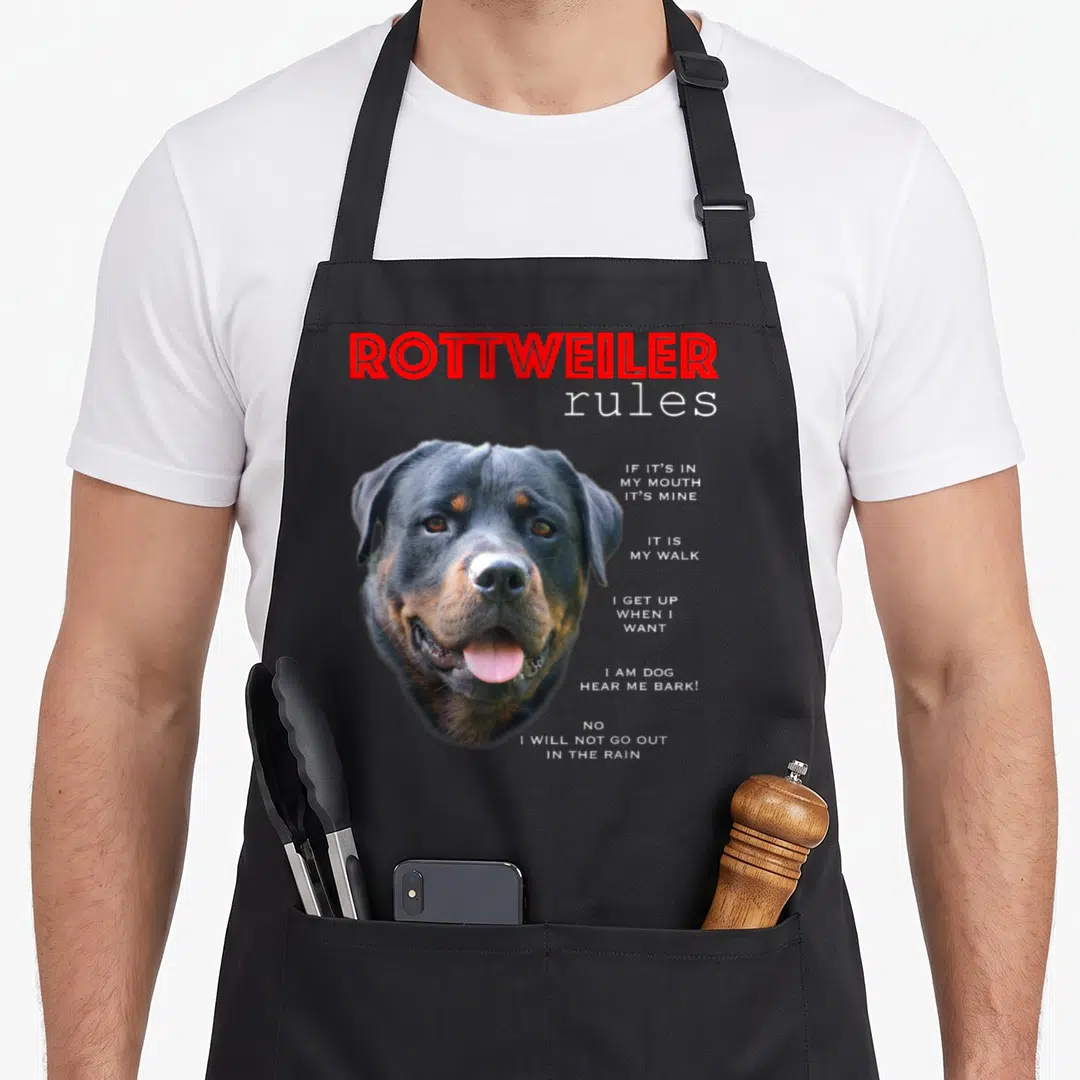 Rule rottweiler apron - Rottweiler head photo with red title and white rule text list on right — shown on a black cotton canvas apron against a white background