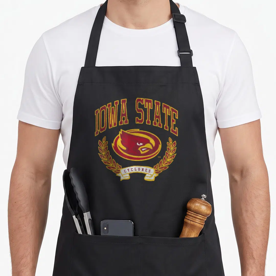 Cyclone clinton iowa apron - Red cardinal head in oval with IOWA STATE text and CYCLONES ribbon framed by laurel wreath — shown on a black cotton canvas apron against a white background