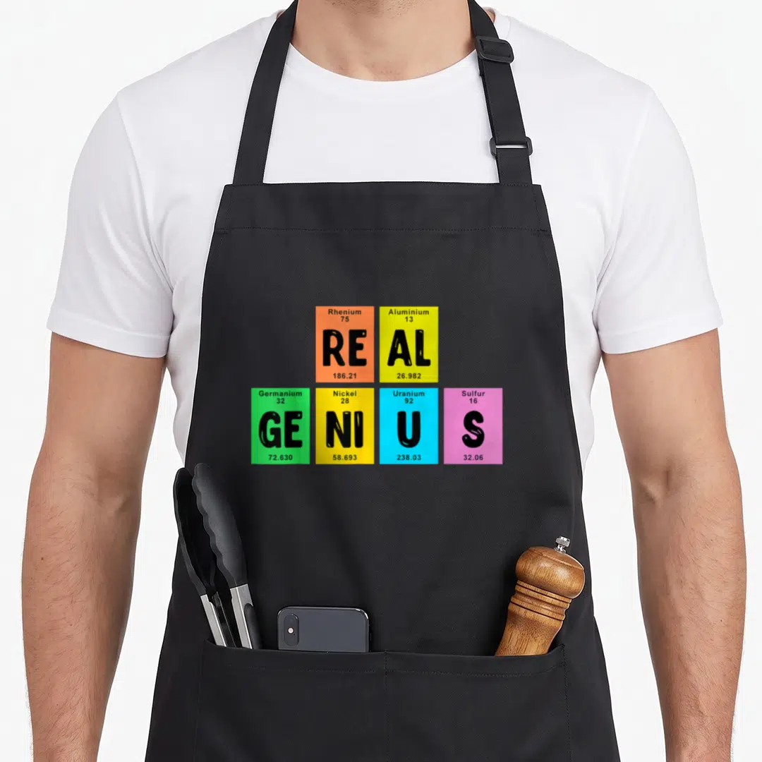 Element genius table apron - Six colored squares with element data spelling real genius typography design — shown on a black cotton canvas apron against a white background