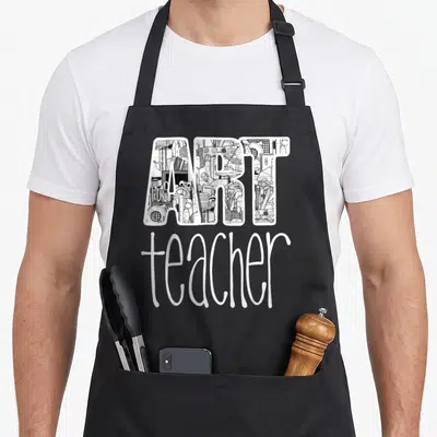 Supply teacher apron - Block letters filled with art supply doodles above white script text reading teacher — shown on a black cotton canvas apron against a white background