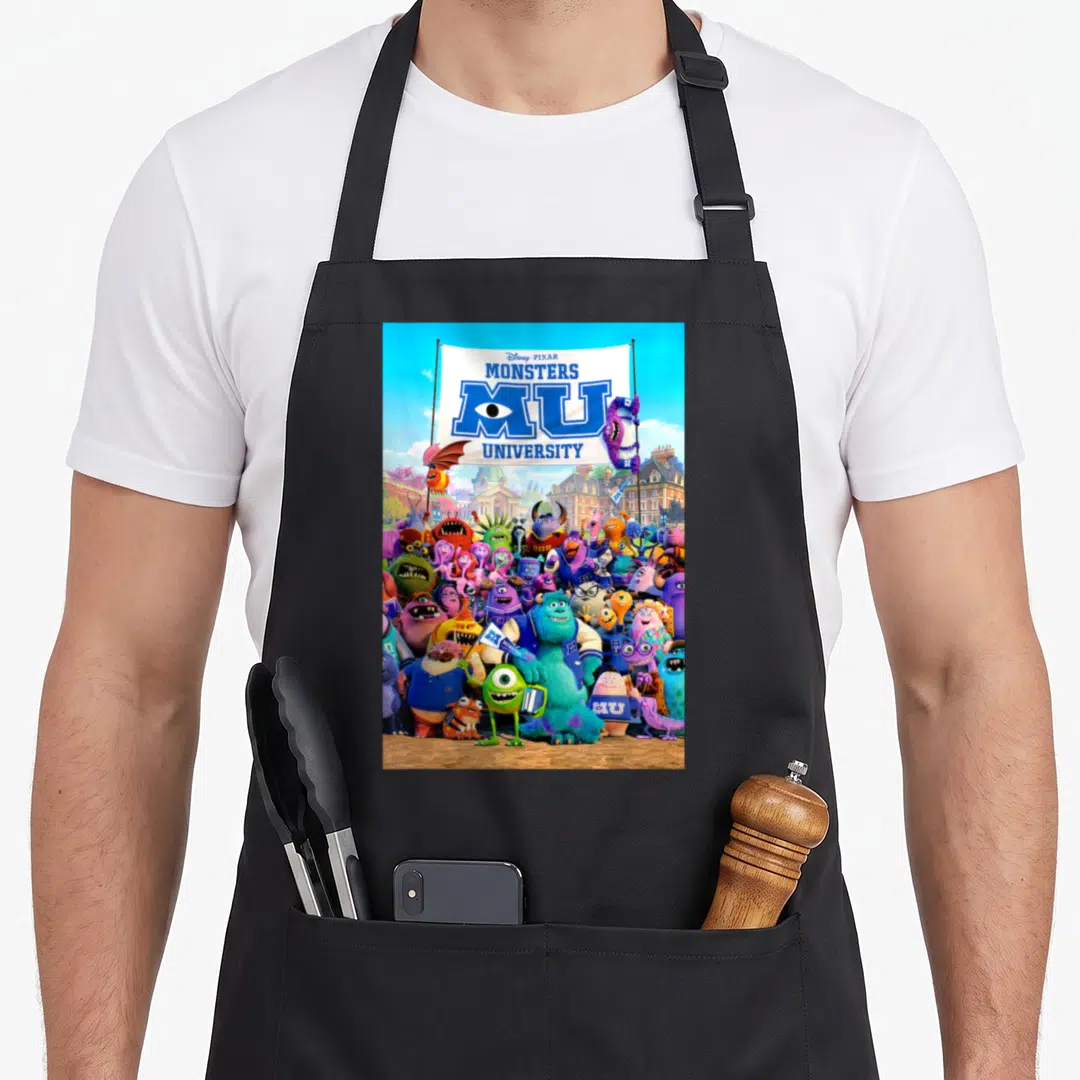 Poster university apron - Disney PIXAR MONSTERS MU UNIVERSITY banner with dense crowd of colorful monsters and pink — shown on a black cotton canvas apron against a white background