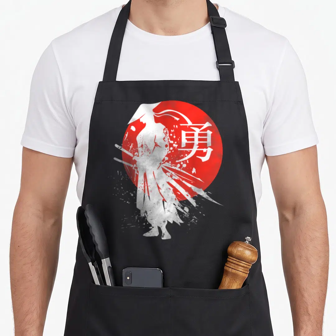 Warrior japan apron - White samurai silhouette standing before red sun with kanji character for courage — shown on a black cotton canvas apron against a white background