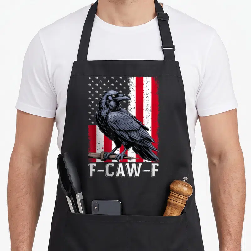 Flag bird aprons - Black crow on branch over distressed red white blue flag with F-CAW-F text — shown on a black cotton canvas apron against a white background