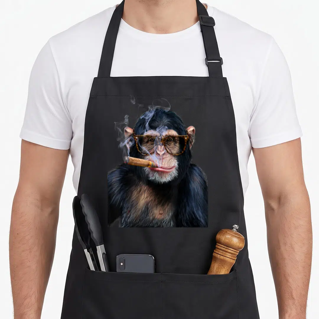 Chimpanzee hip apron - Realistic chimpanzee portrait wearing tortoiseshell sunglasses and smoking a cigar with curling — shown on a black cotton canvas apron against a white background