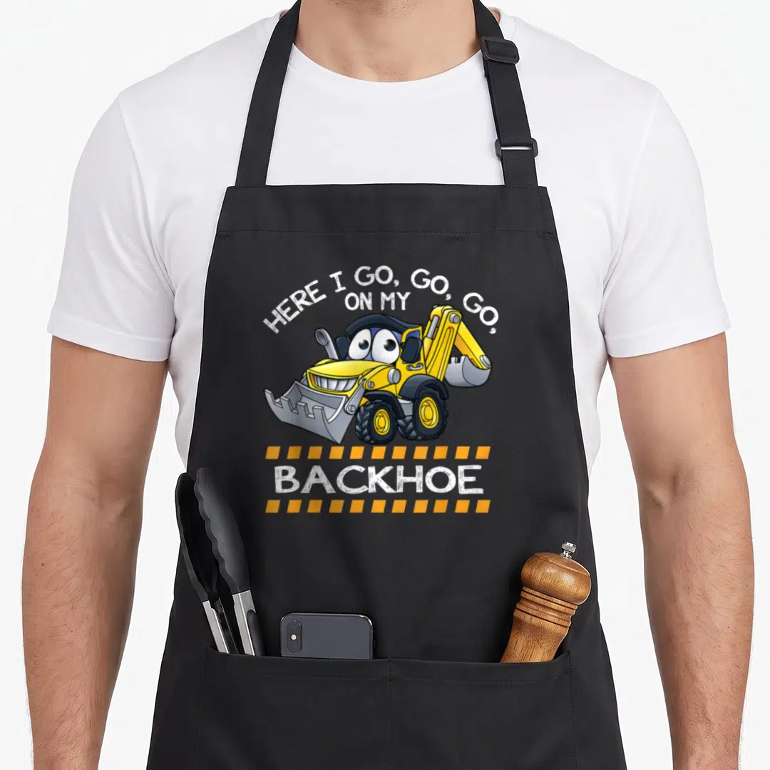 Backhoe digger construction apron - Cartoon yellow backhoe with HERE I GO GO GO text and two yellow dashed lines — shown on a black cotton canvas apron against a white background