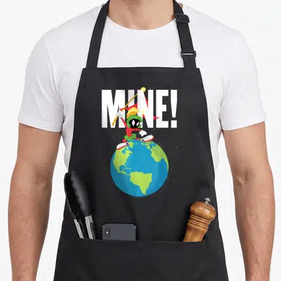 Marvin tunes apron - Cartoon character on globe holding spear with MINE! text in white and colored details — shown on a black cotton canvas apron against a white background