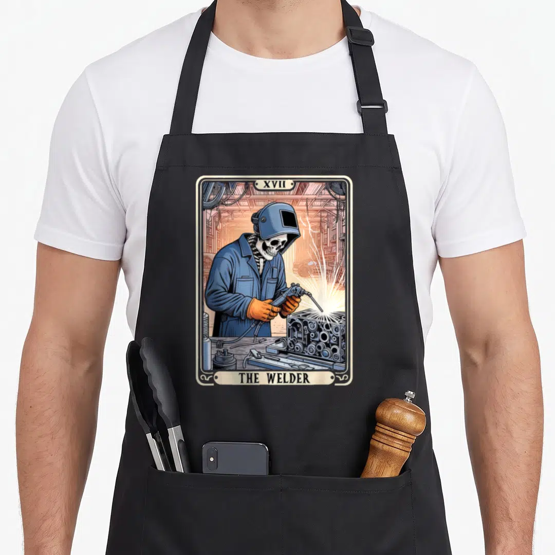 Welder metal worker apron - Skeleton welder in blue helmet holding torch inside retro tarot card frame with text — shown on a black cotton canvas apron against a white background