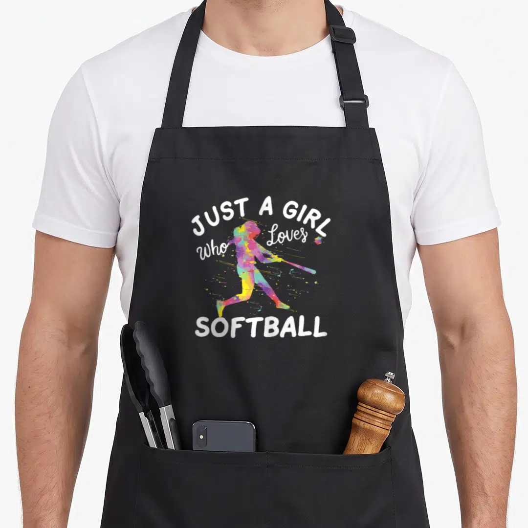 Sport i love softball apron - Watercolor softball batter silhouette with white text JUST A GIRL Who Loves SOFTBALL — shown on a black cotton canvas apron against a white background