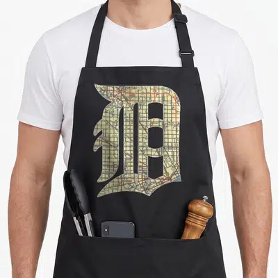 Detroit english apron - Gothic letter D filled with a street map in yellow red blue and white — shown on a black cotton canvas apron against a white background