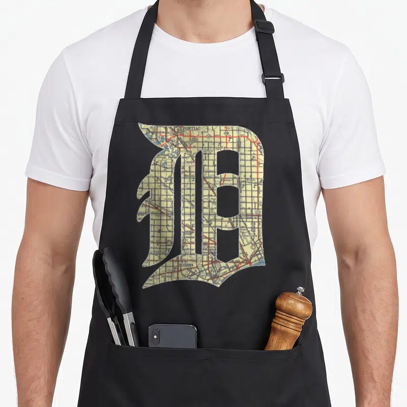 Detroit english apron - Gothic letter D filled with a street map in yellow red blue and white — shown on a black cotton canvas apron against a white background