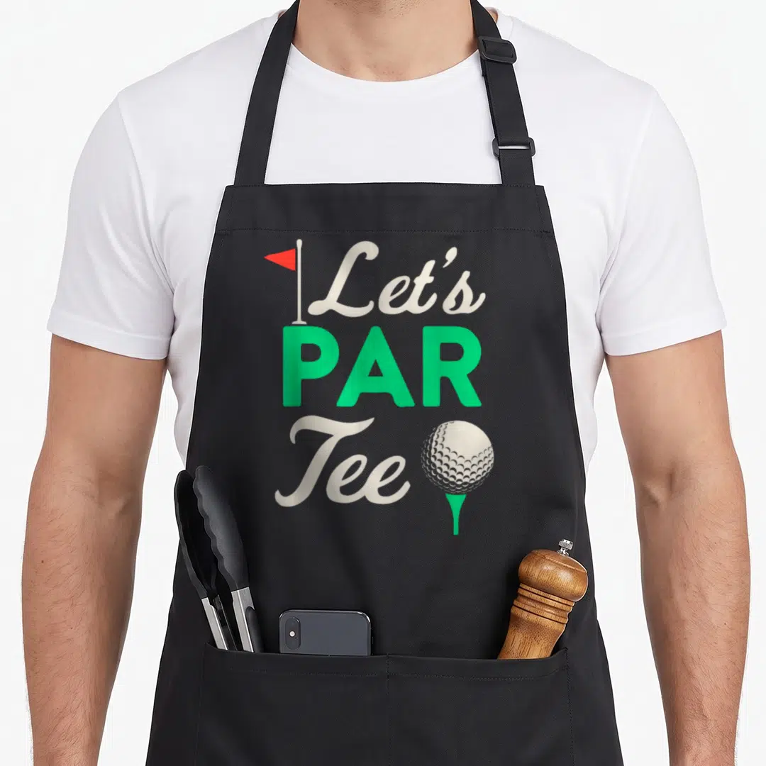 Golfer ball golf apron - Let's PAR Tee text with red flag, green letters, and white golf ball on green tee — shown on a black cotton canvas apron against a white background