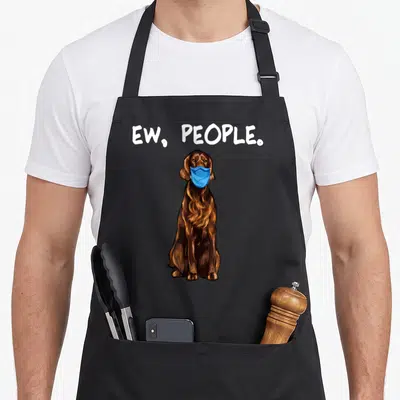 Irish dog face apron - Brown cartoon dog in blue mask with ew people text above — shown on a black cotton canvas apron against a white background