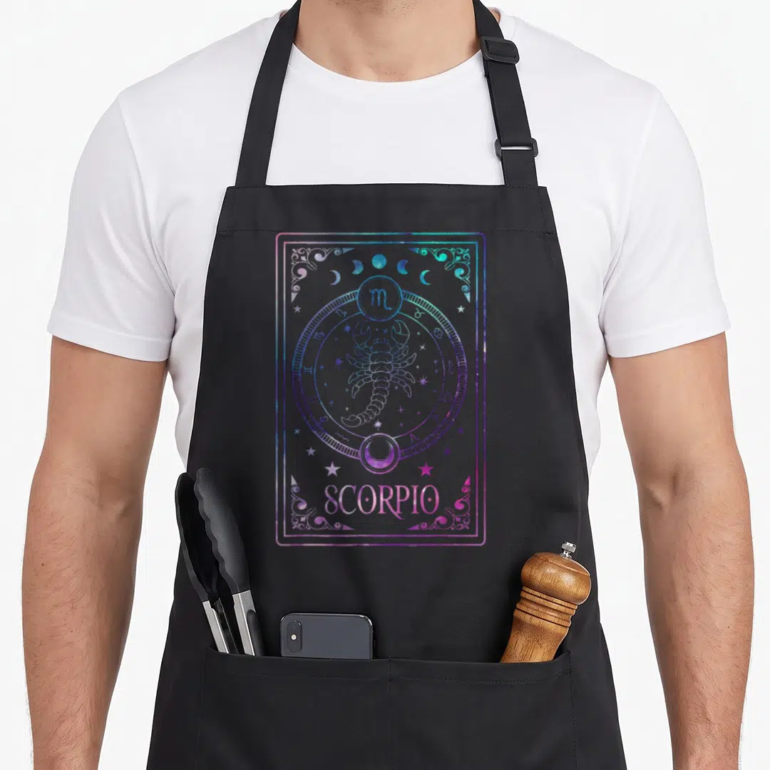 Scorpio tarot birthday apron - Purple and blue line-art scorpion inside zodiac circle with stars and moons — shown on a black cotton canvas apron against a white background