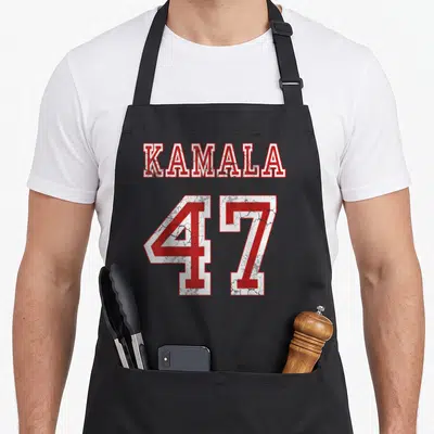 Kamala baggy apron - Red and white KAMALA 47 distressed text on black apron — shown on a black cotton canvas apron against a white background