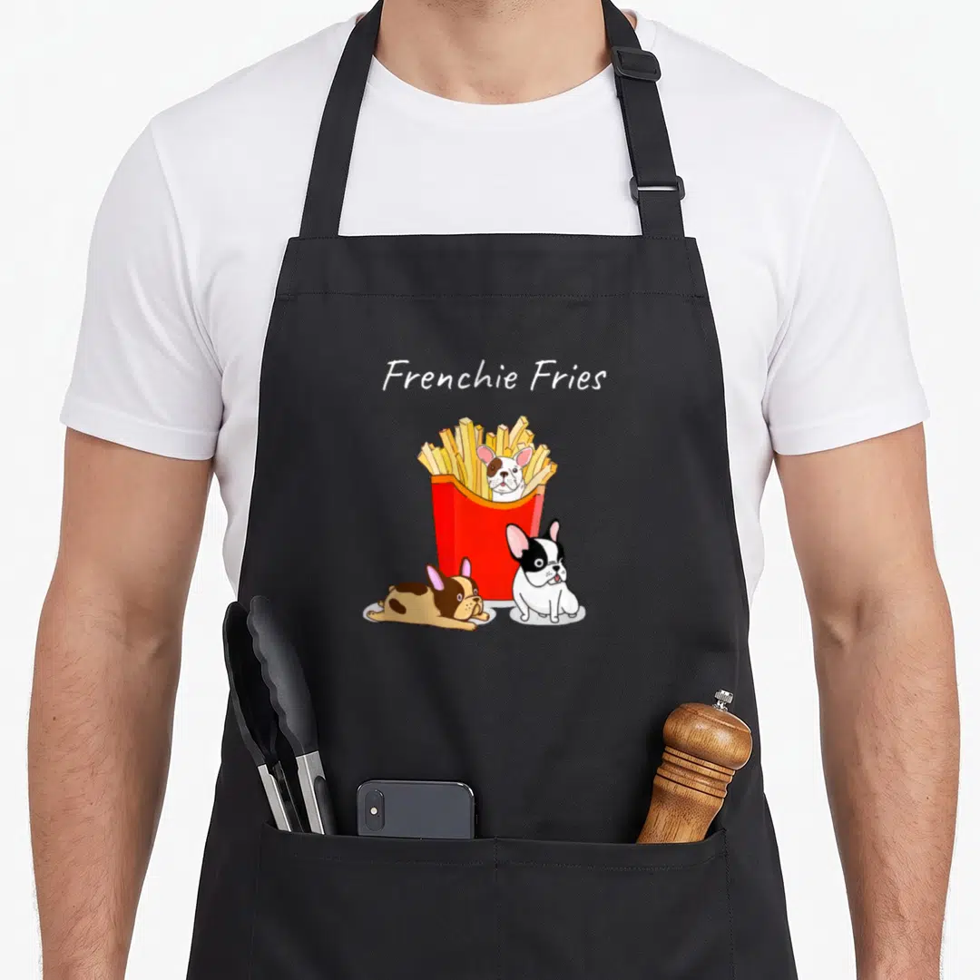 Frenchie fry french bulldog apron - Cartoon Frenchie Fries text with red fry box and three french bulldogs in white — shown on a black cotton canvas apron against a white background