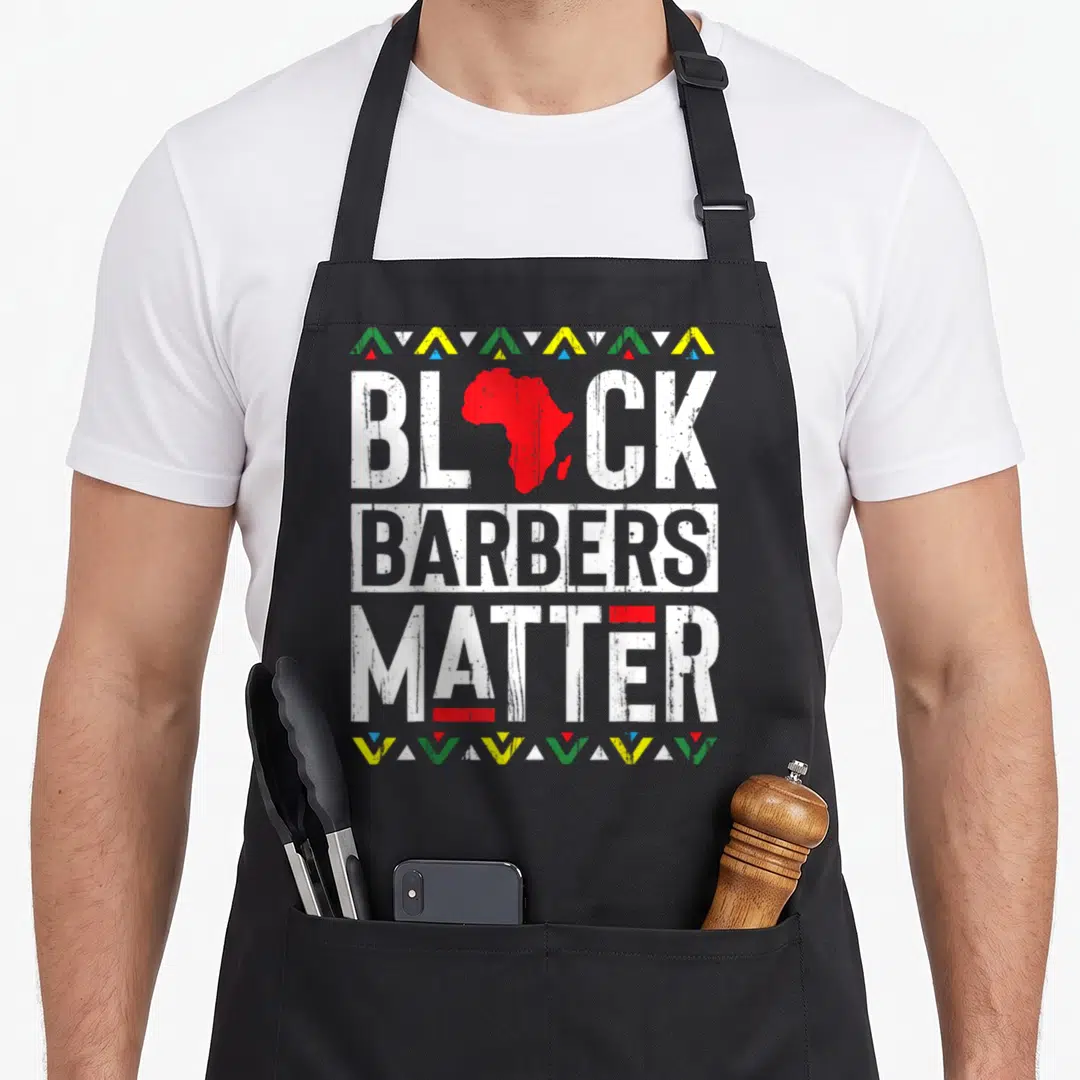 Barber african apron - Black Barbers Matter text with red Africa map and colorful triangle border design — shown on a black cotton canvas apron against a white background