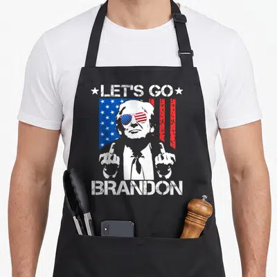 Brandon middle apron - Distressed USA flag with figure making gesture and text — shown on a black cotton canvas apron against a white background