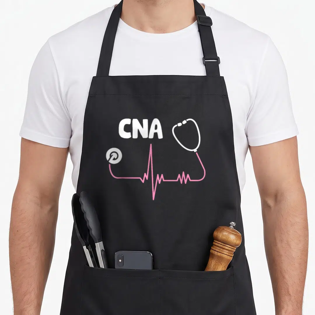 Funny cna nurse apron - White CNA text above pink stethoscope tubing forming a heartbeat line connecting chest piece — shown on a black cotton canvas apron against a white background