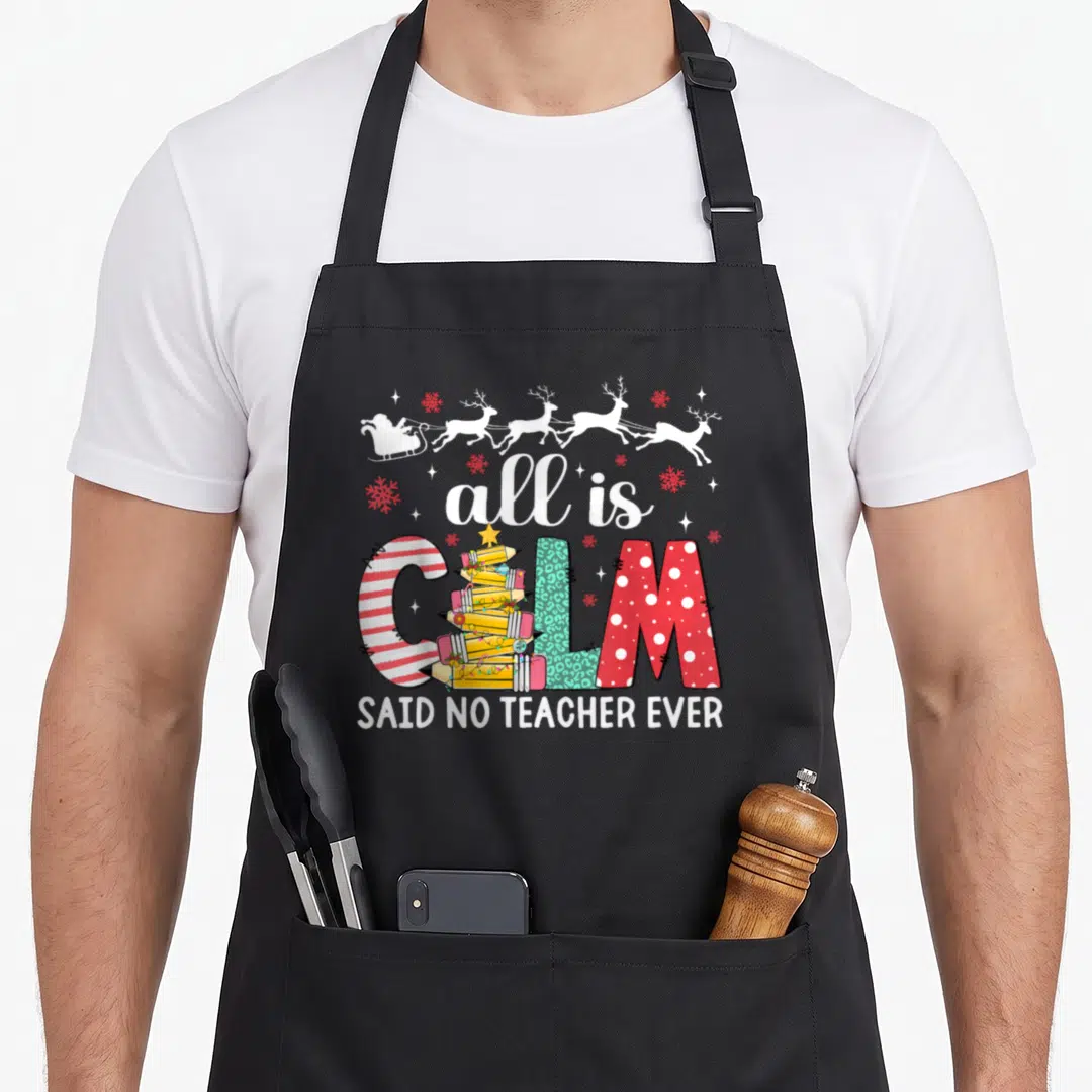 Teacher christmas tree apron - Santa sleigh above text where L is a pencil tree reading all is calm said no teacher ever — shown on a black cotton canvas apron against a white background