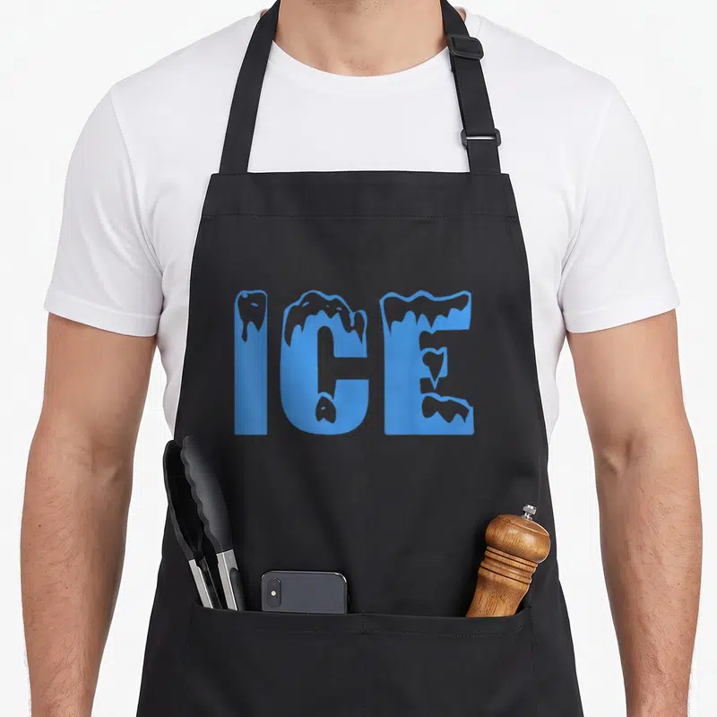 Ice halloween apron - Blue typography spelling ICE with grey dripping edges on a dark background — shown on a black cotton canvas apron against a white background