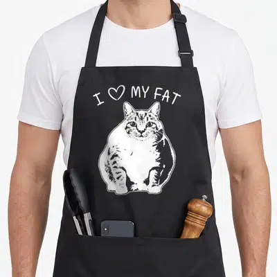 Funny cat fat man in apron - White cartoon fat cat sitting below arched I Love My Fat text — shown on a black cotton canvas apron against a white background