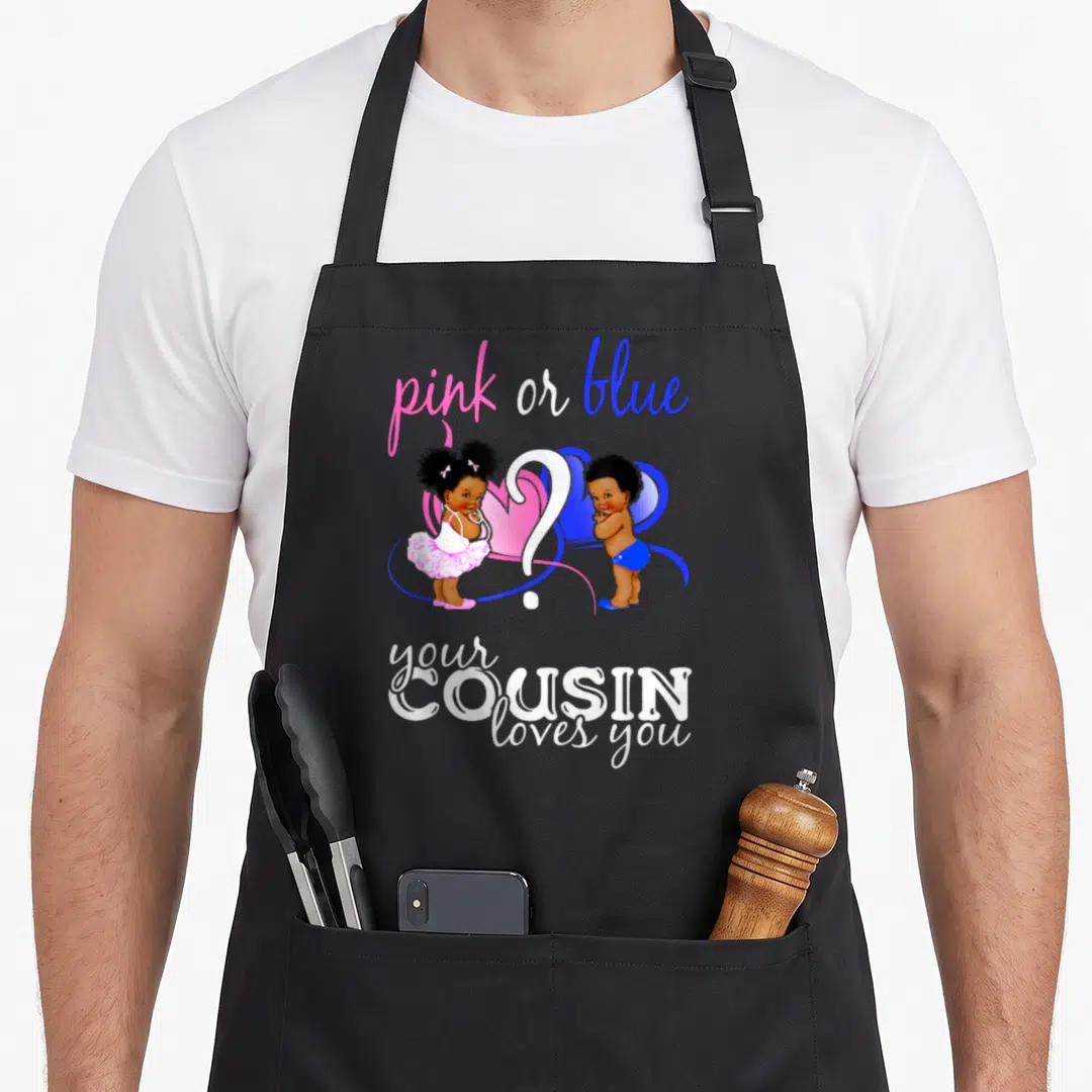 Blue cousin apron or apron - Pink or blue text above cartoon babies and your COUSIN loves you in white lettering — shown on a black cotton canvas apron against a white background