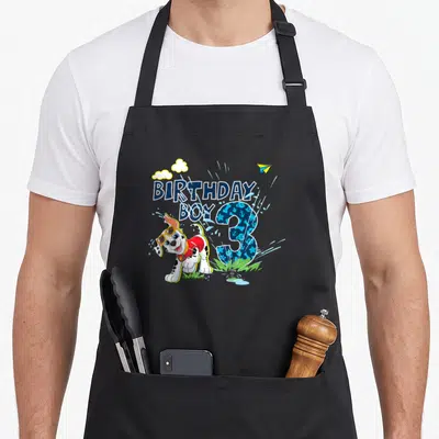 Birthday marshalls apron - Dalmatian puppy next to BIRTHDAY BOY text and patterned number 3 with sprinkler — shown on a black cotton canvas apron against a white background
