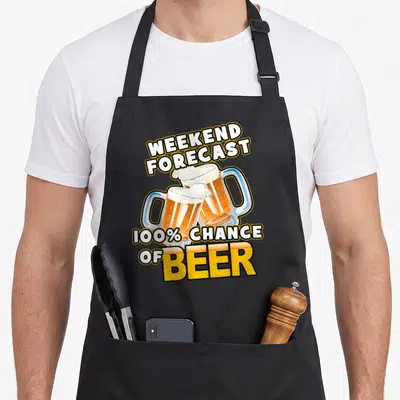 Weekend hop apron - Two clinking amber beer mugs under arched text reading Weekend Forecast 100% Chance of Beer — shown on a black cotton canvas apron against a white background