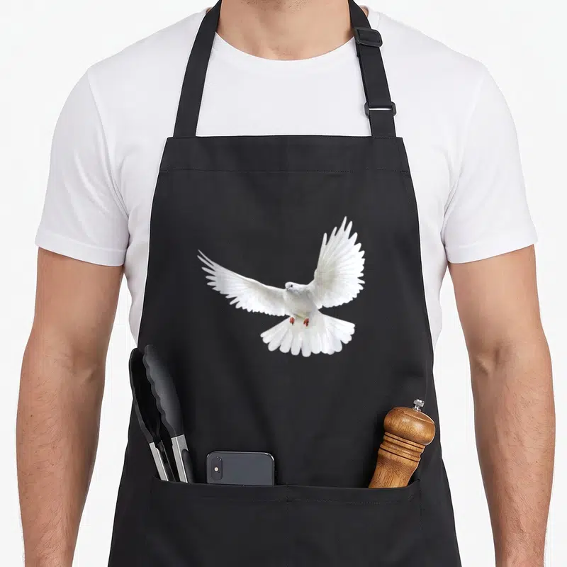 Peaceful flying apron - White dove photo silhouette in flight on black bib apron — shown on a black cotton canvas apron against a white background