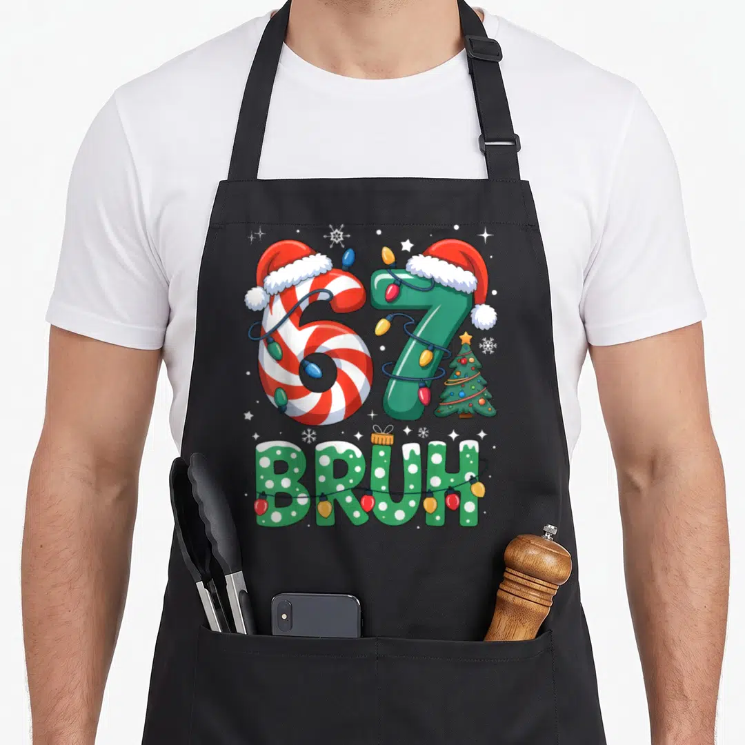Seven christmas apron - Cartoon 67 wearing Santa hats wrapped in lights with BRUH text below — shown on a black cotton canvas apron against a white background