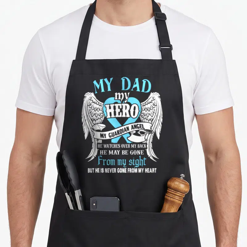 Hero guardian angels and aprons - My Dad my Hero text with blue ribbon, white wings, and guardian angel banner — shown on a black cotton canvas apron against a white background