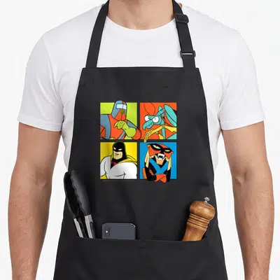 Hero ghost apron - Four cartoon characters in red blue yellow green orange squares grid — shown on a black cotton canvas apron against a white background