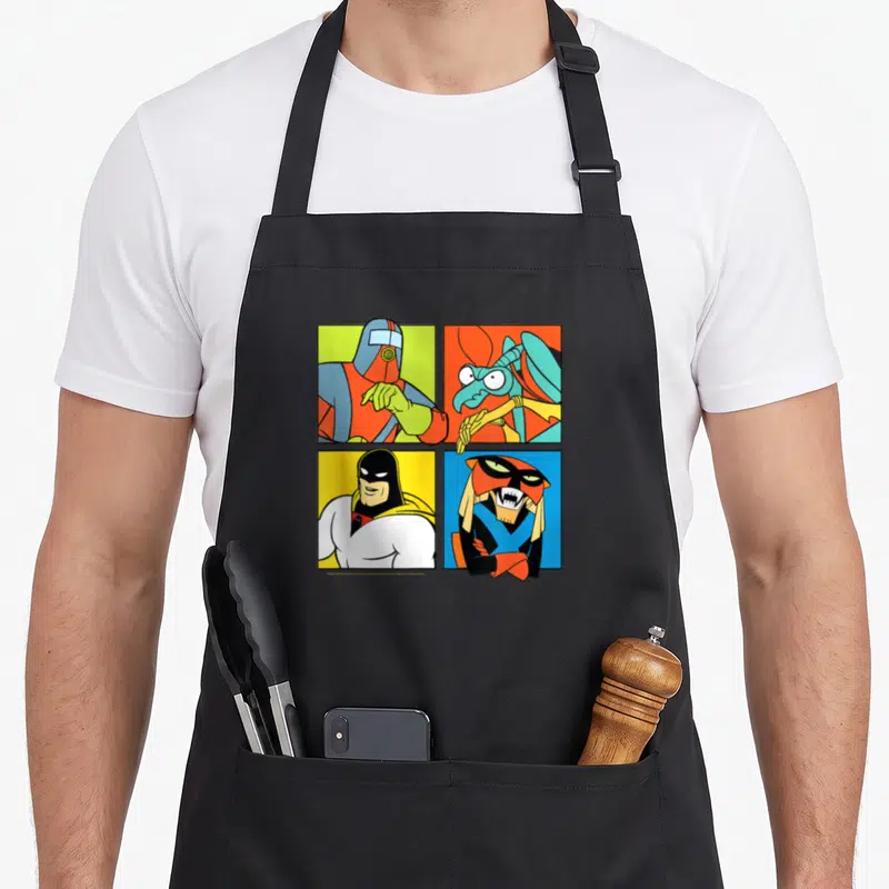 Hero ghost apron - Four cartoon characters in red blue yellow green orange squares grid — shown on a black cotton canvas apron against a white background