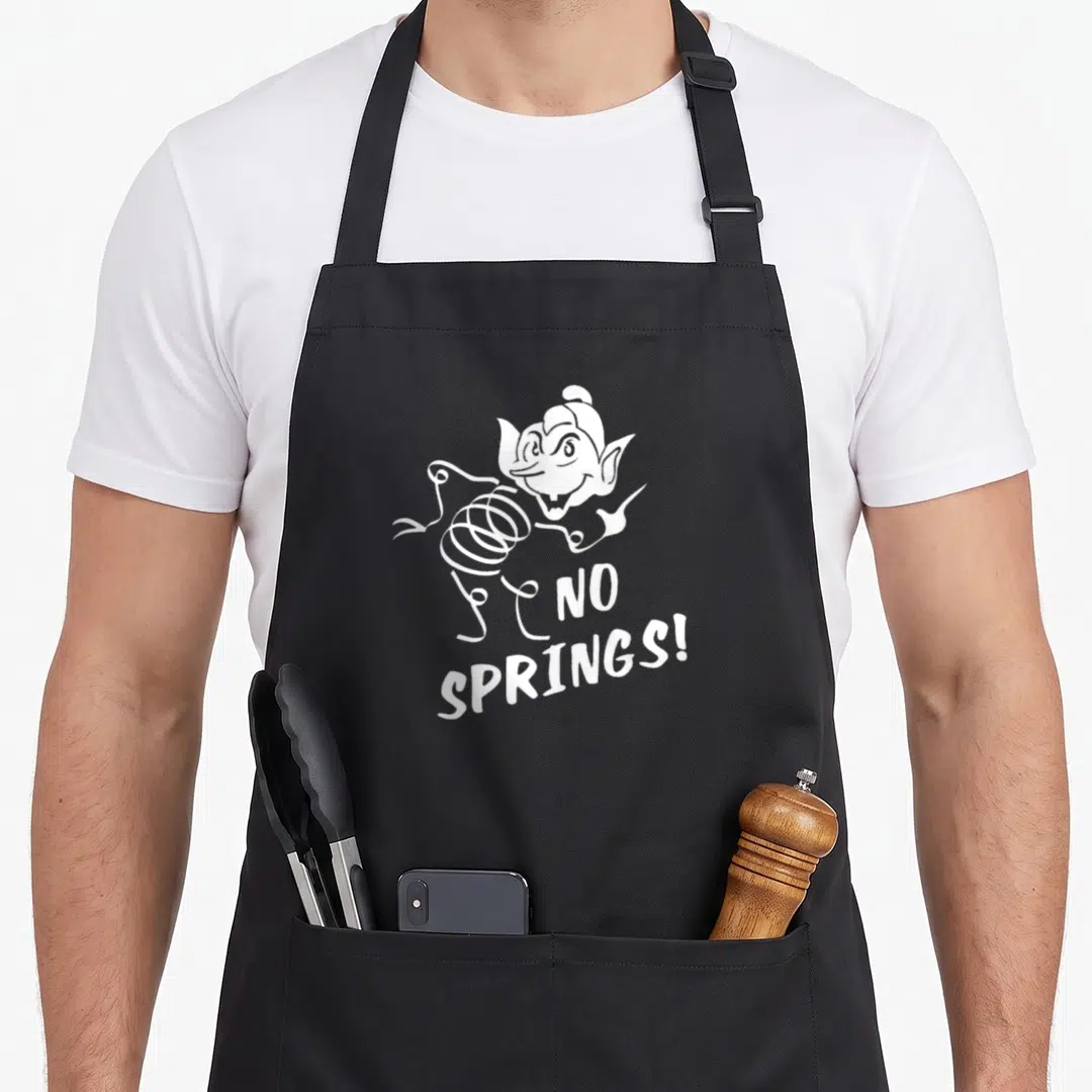 Coily science apron - White cartoon creature with spring body and no springs text — shown on a black cotton canvas apron against a white background