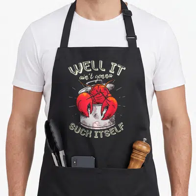 Well lobster apron - Red cartoon lobster in grey pot with arched beige text reading well it ain't gonna suck itself — shown on a black cotton canvas apron against a white background