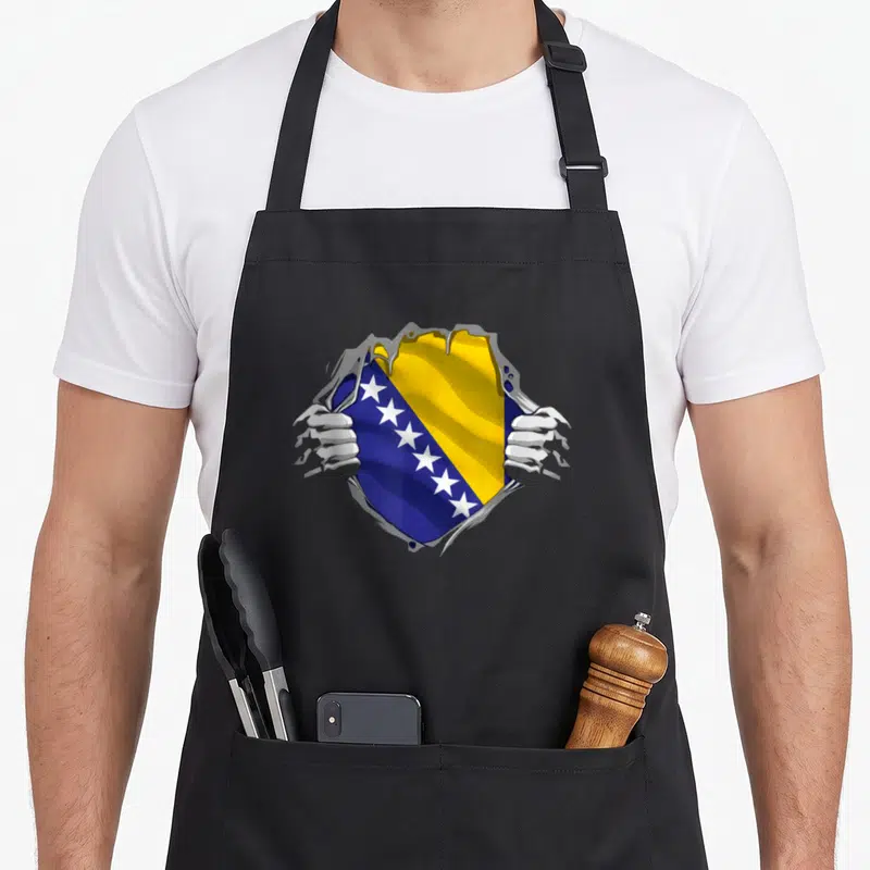 Flag bosnian girl apron - Hands tearing grey surface to reveal blue yellow and white Bosnia flag with white stars — shown on a black cotton canvas apron against a white background