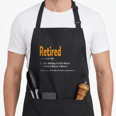 Retired gag aprons - Orange Retired dictionary definition text with speaker icon and white quote on grey background — shown on a black cotton canvas apron against a white background